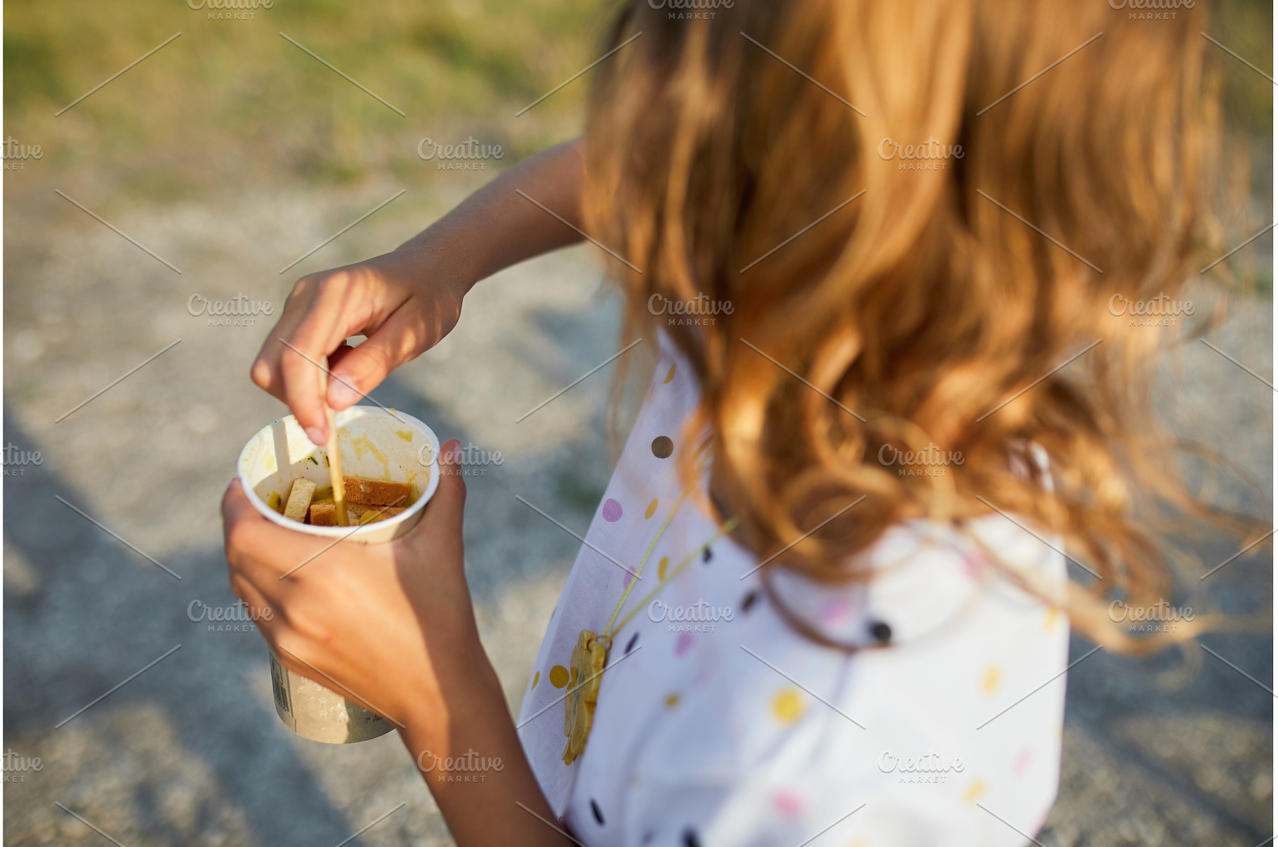 Child enjoying a snack on a sunny, a Food & Drink Photo by IlliaBondarPhotography
