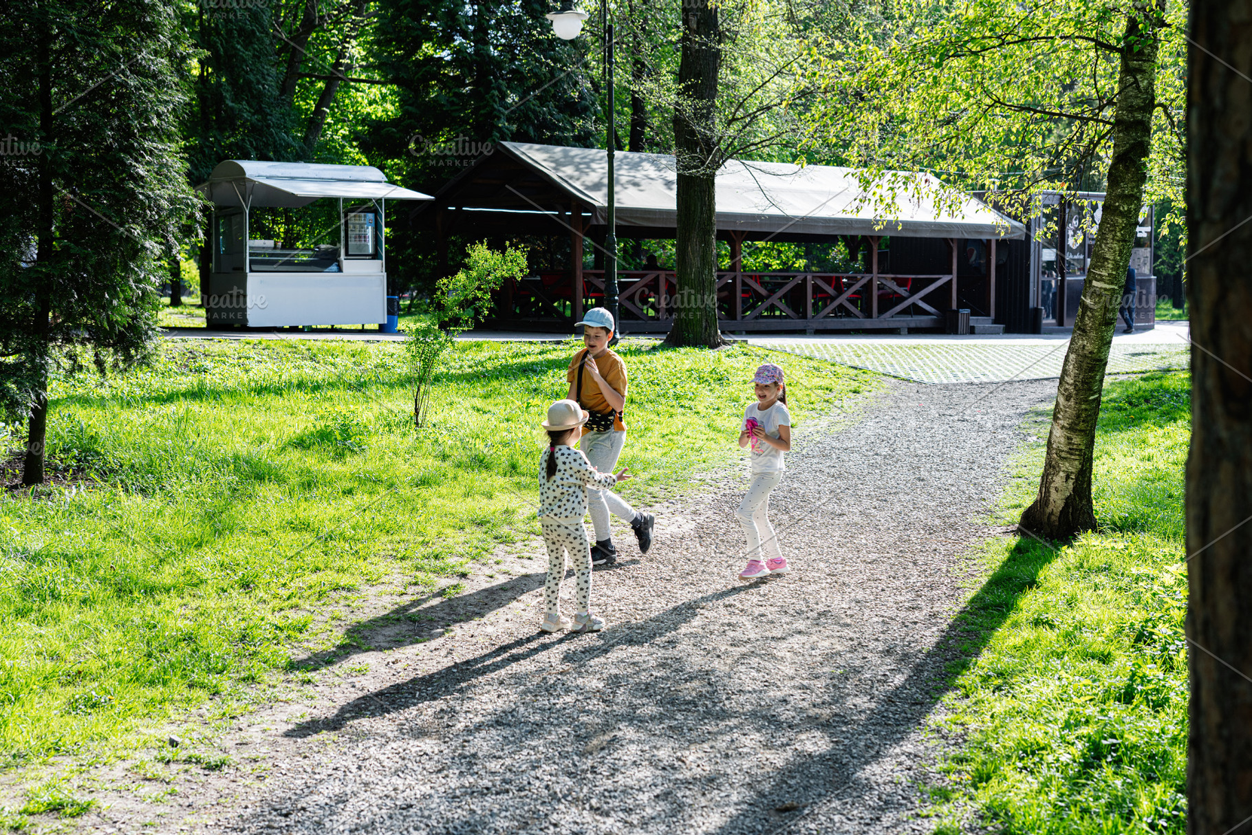 Children enjoying a walk in a sunny park surrounded by greenery, a Person Photo by AS photostudio