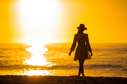 Young beautiful woman at straw hat on the beach at sunset, a Person Photo by travnikovstudio