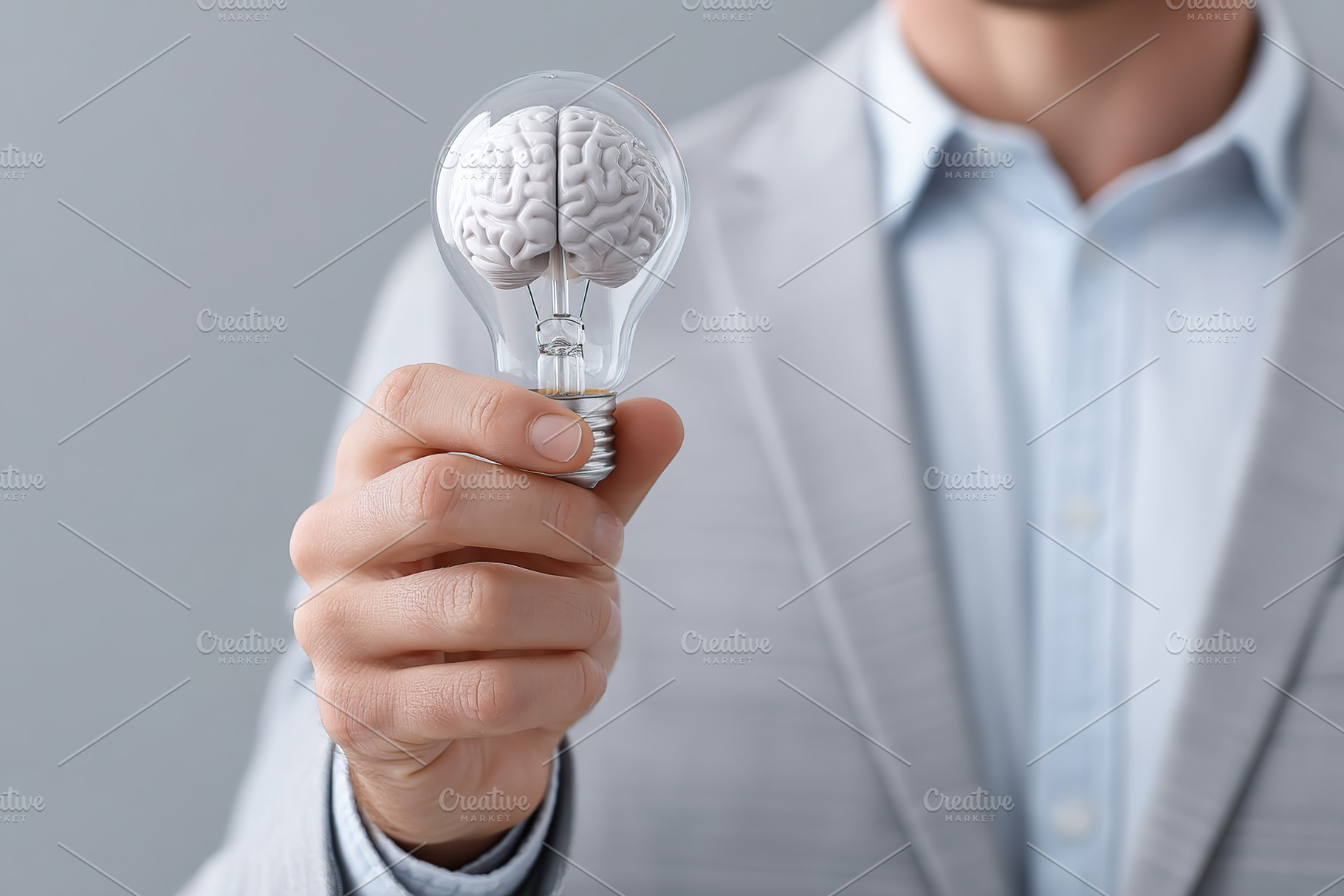 Innovative light bulb with brain design held by a person in a light gray suit i, a Business Photo by AlyaAnd