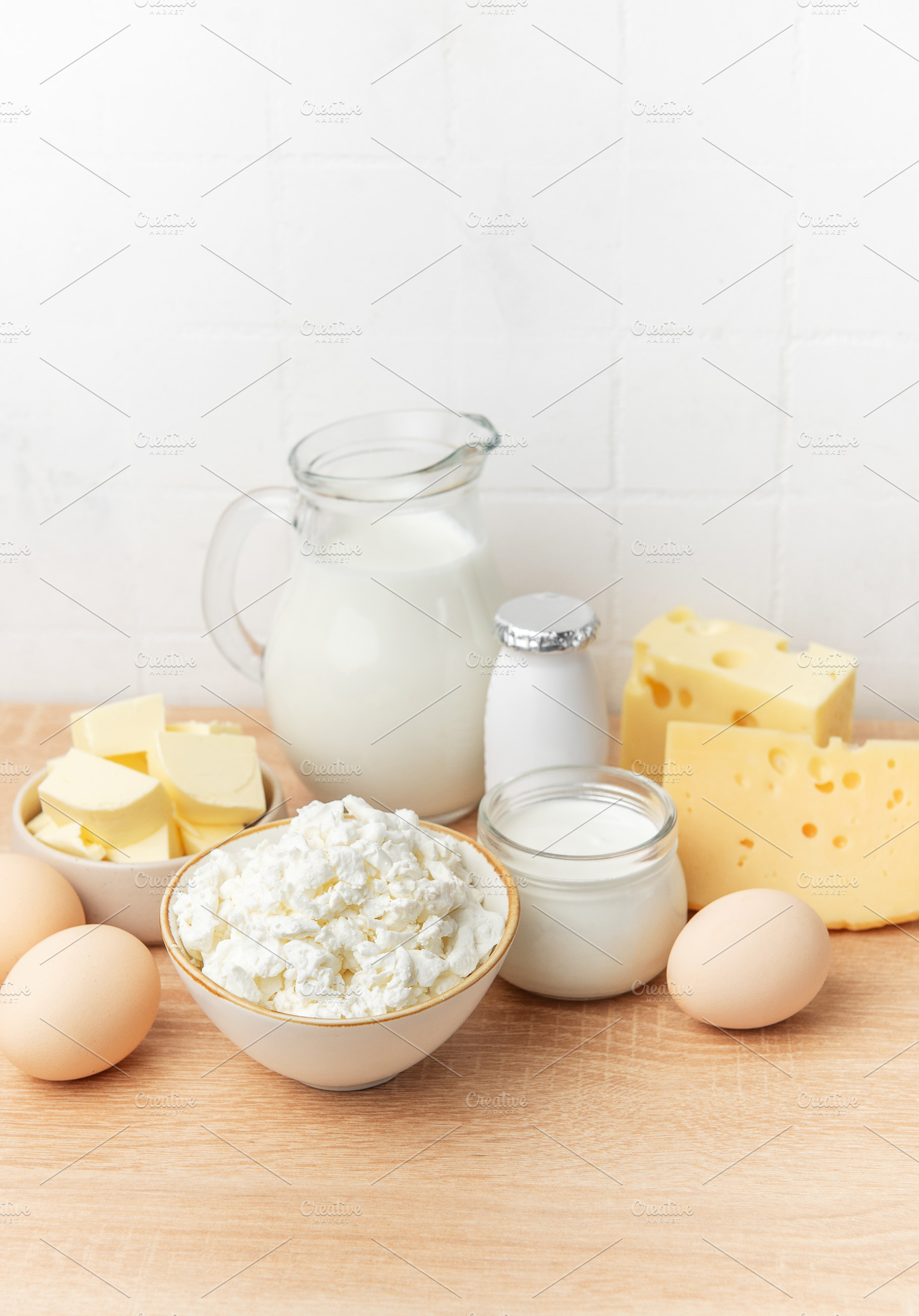 Assortment of fresh dairy products and eggs on wooden background, a Food & Drink Photo by Olena Rudo