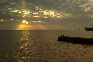 Sunset rays breaking through clouds over the sea, a Nature Photo by DanFLCreativo