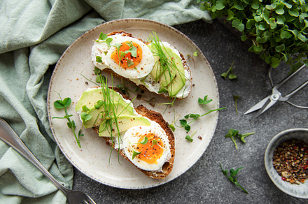 Bread toast, boiled eggs, avocado slice, microgreens on a plate, a Food & Drink Photo by Olena Rudo