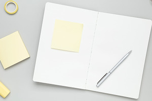 Tidy workspace featuring notebook, glasses, and stationery fostering productive