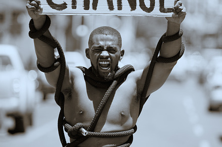 Protest, city and portrait of a man with a poster against discrimination, racism or equality. Rope, sign and angry guy walking, protesting and shouting to fight for change, human rights or justice., a Photo by Peopleimages.com