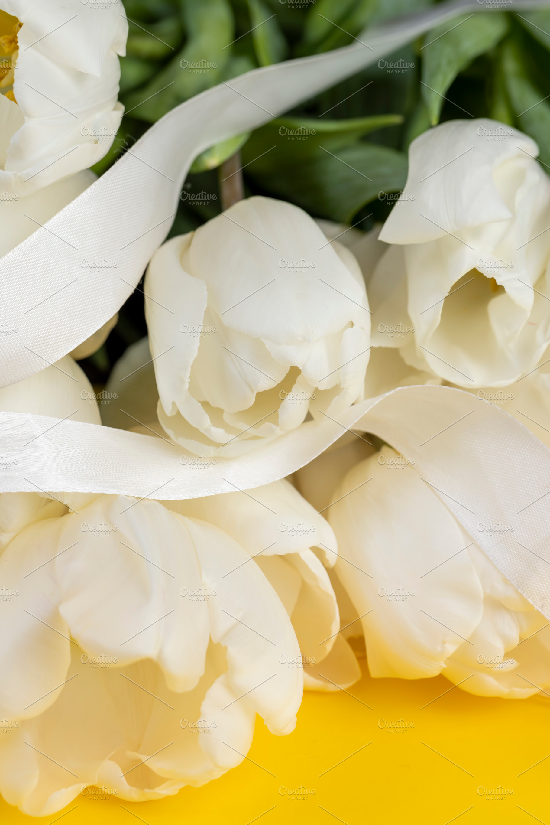 tulips on yellow paper and white ribbon , yellow paper and white tulip flowers, a Photo by rsoollAI