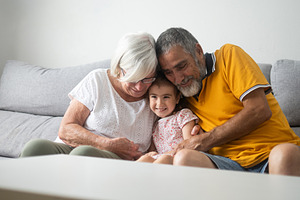 Grandparents embracing their smiling granddaughter, a Person Photo by etorres69