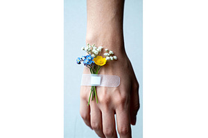 Hand with small wildflowers secured, a Health & Medical Photo by tilialucida