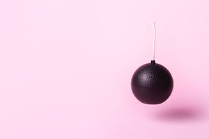 Minimalist black cartoon bomb with fuse suspended against pastel, a Technology Photo by Ales Munt