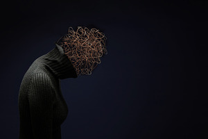 Silhouetted woman bows her head with tangled wire, mental stress, a Photo by salmon.black