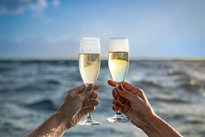 Arm raising a champagne glass from the middle of the sea, a Food & Drink Photo by DanFLCreativo