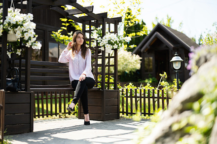 Young beautiful brunette woman in shirt sit on wooden bench with, a Person Photo by AS photostudio