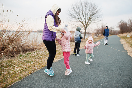 Mother with kids jump and having fun on the path by the lake., a Person Photo by AS photostudio