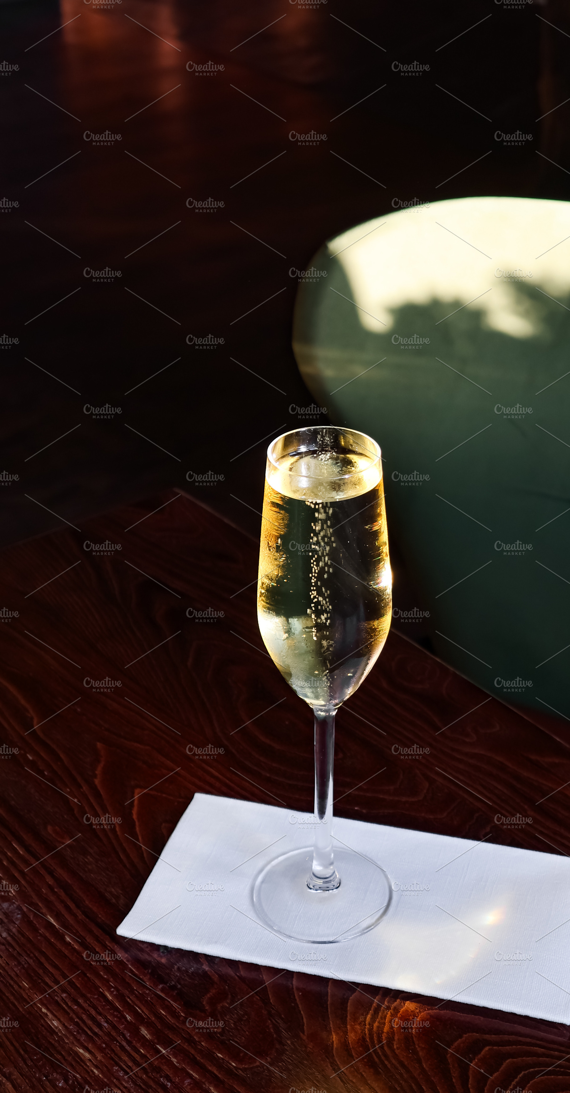 Sparkling champagne in a flute glass on a white napkin at a dim, a Photo by Studio ANNA