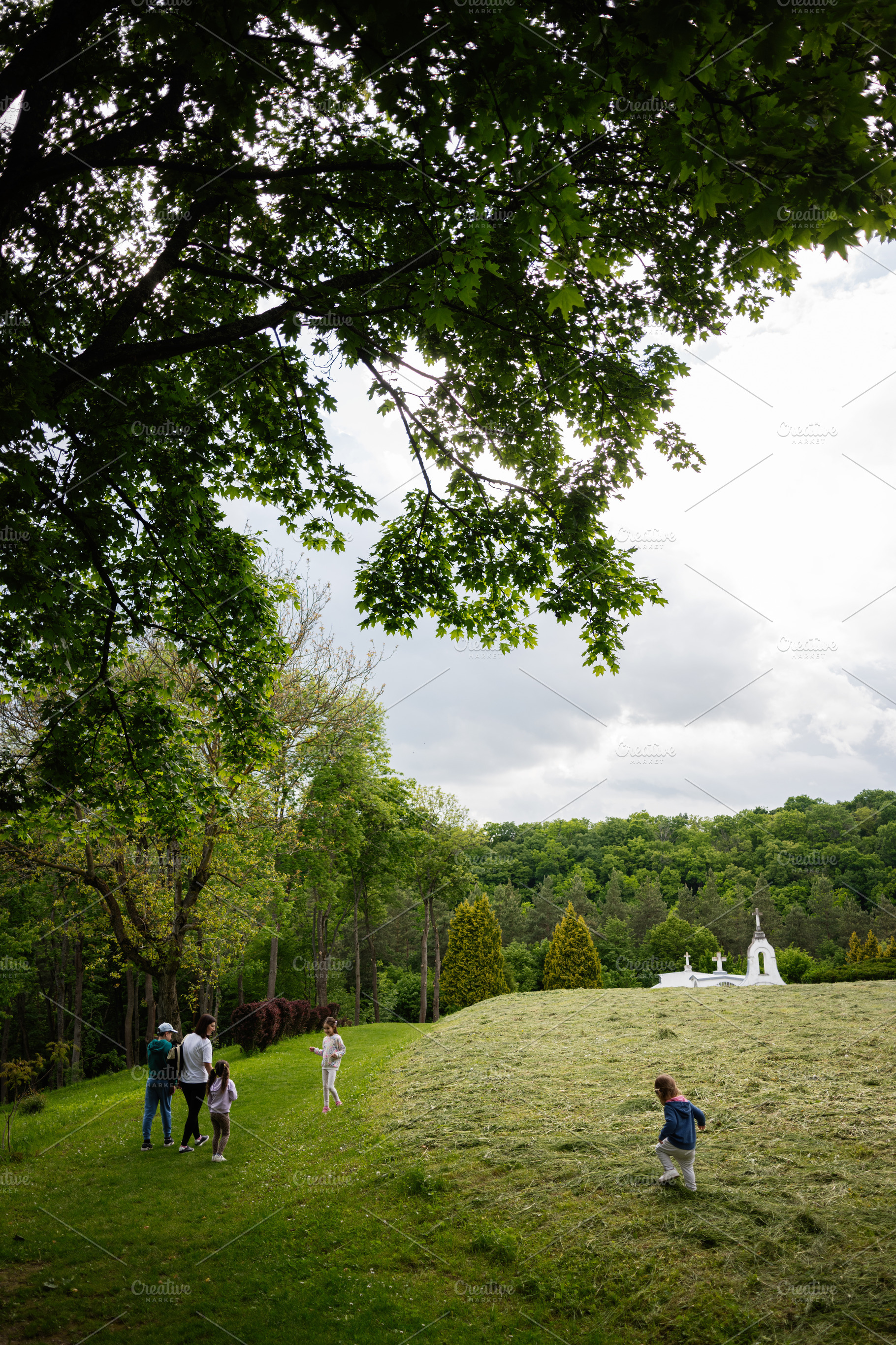 Family exploring a serene countryside with greenery and a charming white chapel, a Person Photo by AS photostudio