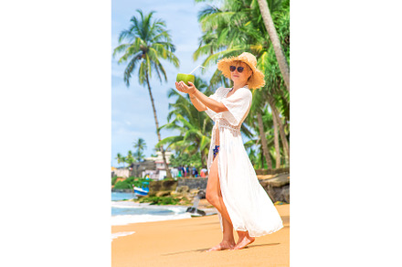 Girl on the beach drinks coconut, a Person Photo by yanadjana