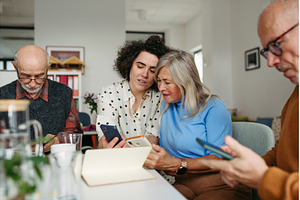 Tutor teaching seniors about phone, a Technology Photo by HalfPoint