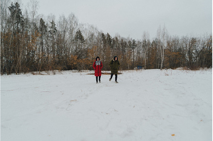 Two individuals stroll across a vast