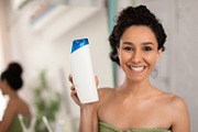 Smiling woman showing shampoo bottle with mockup for design at camera, advertis, a Photo by Prostock-Studio (Thumbnail 1 of 2)