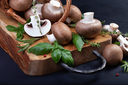 Fresh champignon mushrooms on dark wooden table