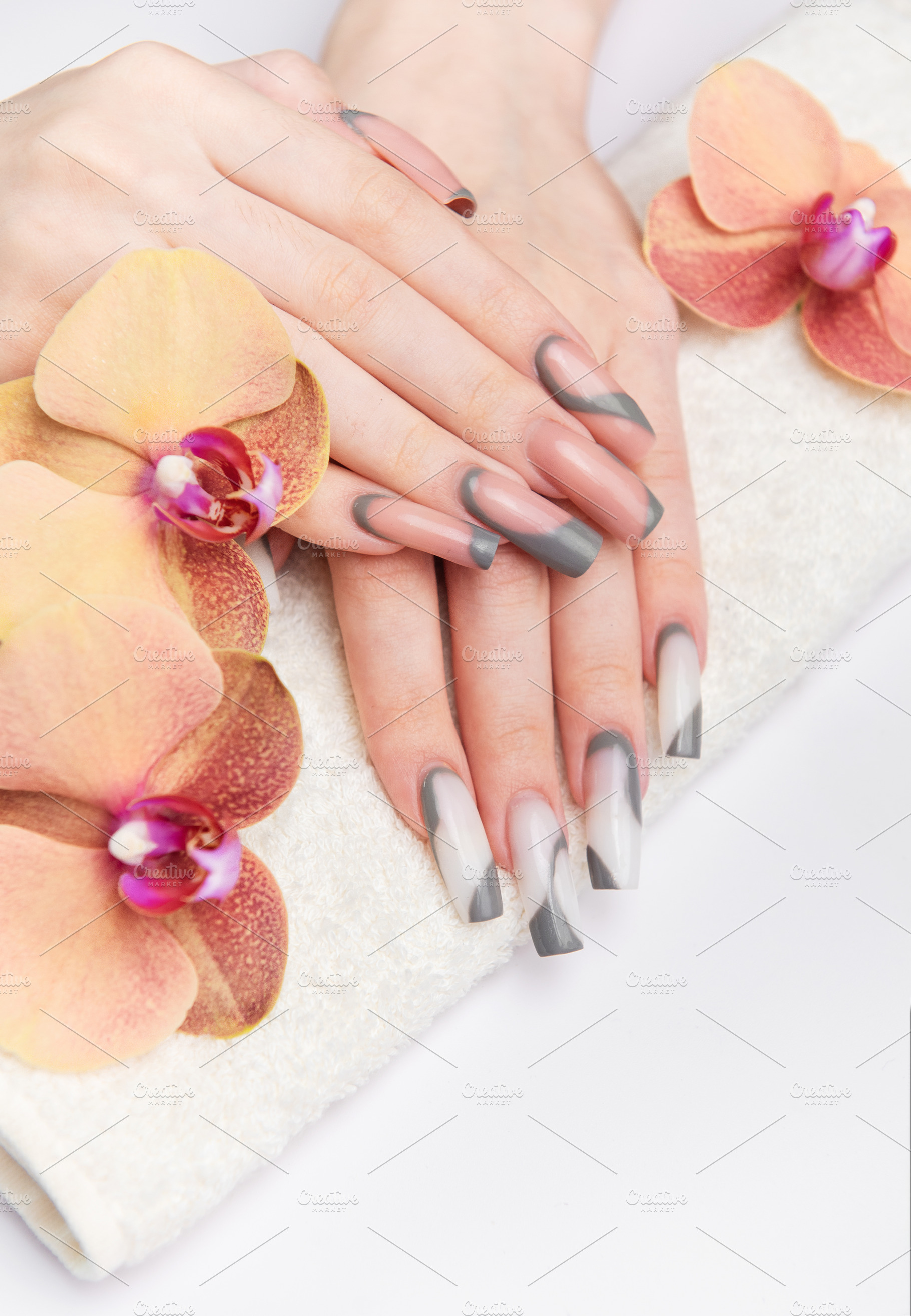 Woman's hands receiving professional manicure on towel with orch, a Beauty & Fashion Photo by Olena Rudo