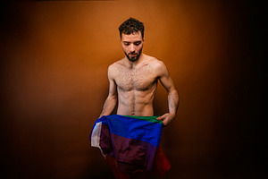 Man expressing lgbt identity holding pride flag, a Photo by karrastock