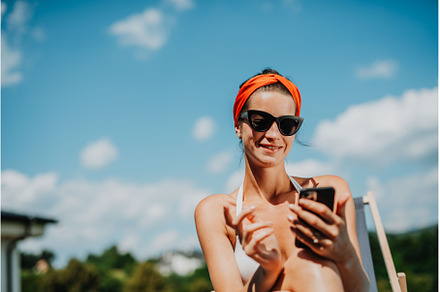 Young woman sitting by swimming pool