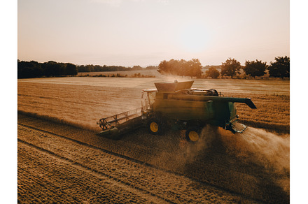 Aerial view of a harvester working, an Industrial Photo by HalfPoint