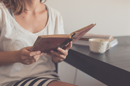 Young woman reading an old book featuring holidays, summertime, and reading