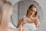 Young lady cleaning teeth in the morning, applying toothpaste on toothbrush, st, a Photo by Prostock-Studio (Thumbnail 3 of 3)