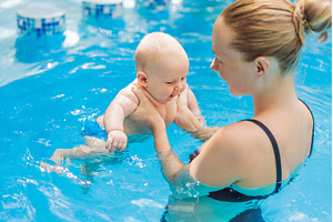 Mother bathing her baby in a, a Sports & Recreation Photo by Elizaveta Galitskaya