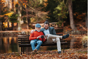 Senior father and his son sitting on, a Person Photo by HalfPoint