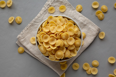Dry, Uncooked Orecchiette Pasta in a Bowl, top view. Flat lay, o, a Food & Drink Photo by LiudmylaChuhunova