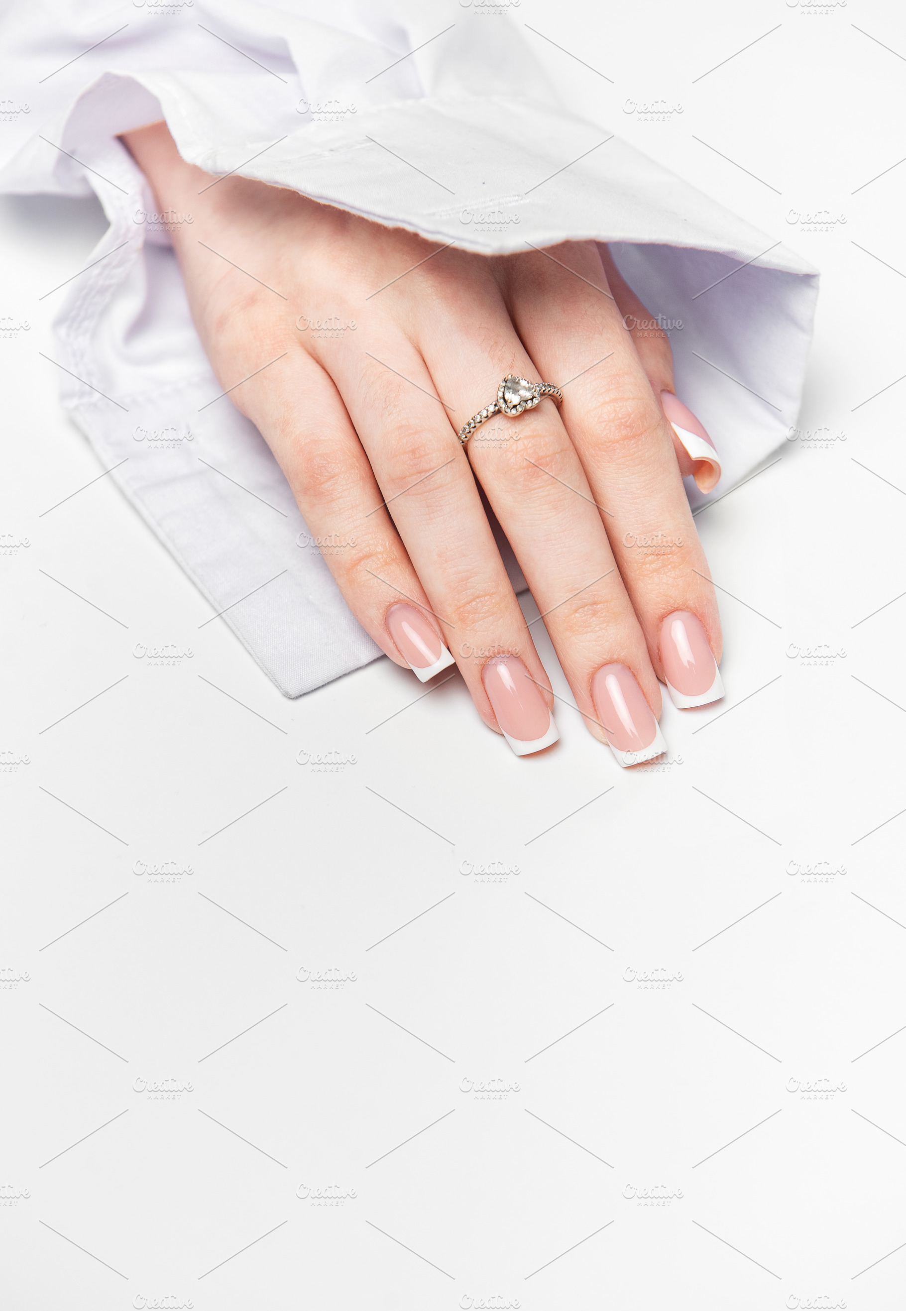 Woman hand showing french manicure and elegant ring on white bac, a Beauty & Fashion Photo by Olena Rudo