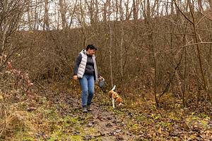 Woman and beagle walking on a muddy path, a Photo by Grafvision photography