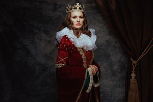 medieval queen in red dress with white collar and crown, a Person Photo by Alliance Images