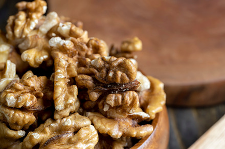 Peeled walnuts in a wooden bowl on the table, a Photo by MyPhotos