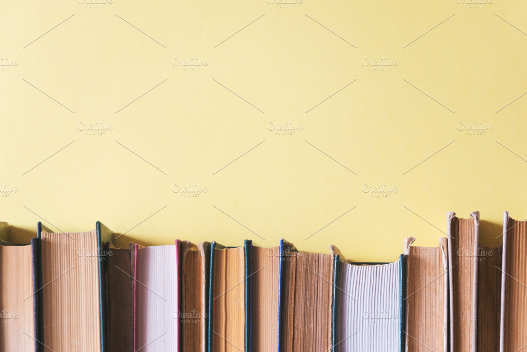 Old books on a yellow background, a School & Education Photo by Ti-Di