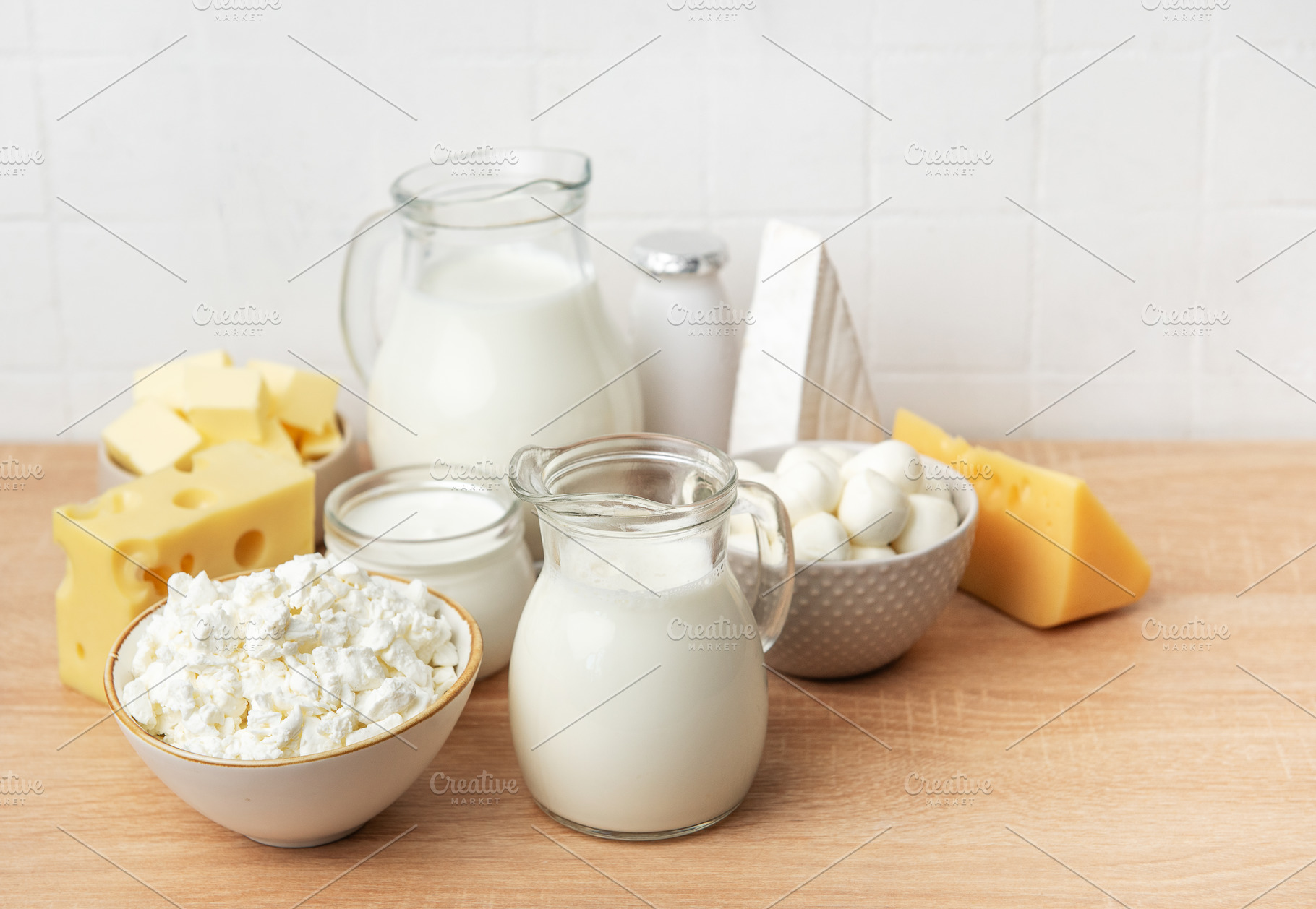 Assortment of fresh dairy products on wooden table, a Food & Drink Photo by Olena Rudo