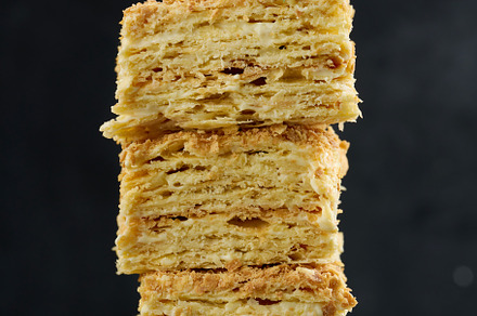 A stack of baked Napoleon pie slices with cream. Puff pastry, delicious dessert, a Food & Drink Photo by ndanko