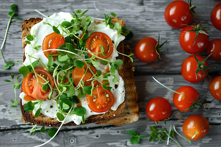 Sandwich with cream cheese, microgreens and tomatoes on wooden table, a Food & Drink Photo by AlyaAnd
