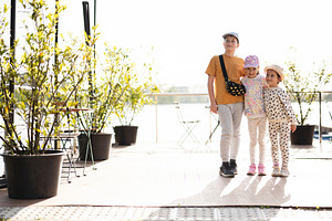 Children enjoying a sunny outdoor day near a scenic garden, a Person Photo by AS photostudio
