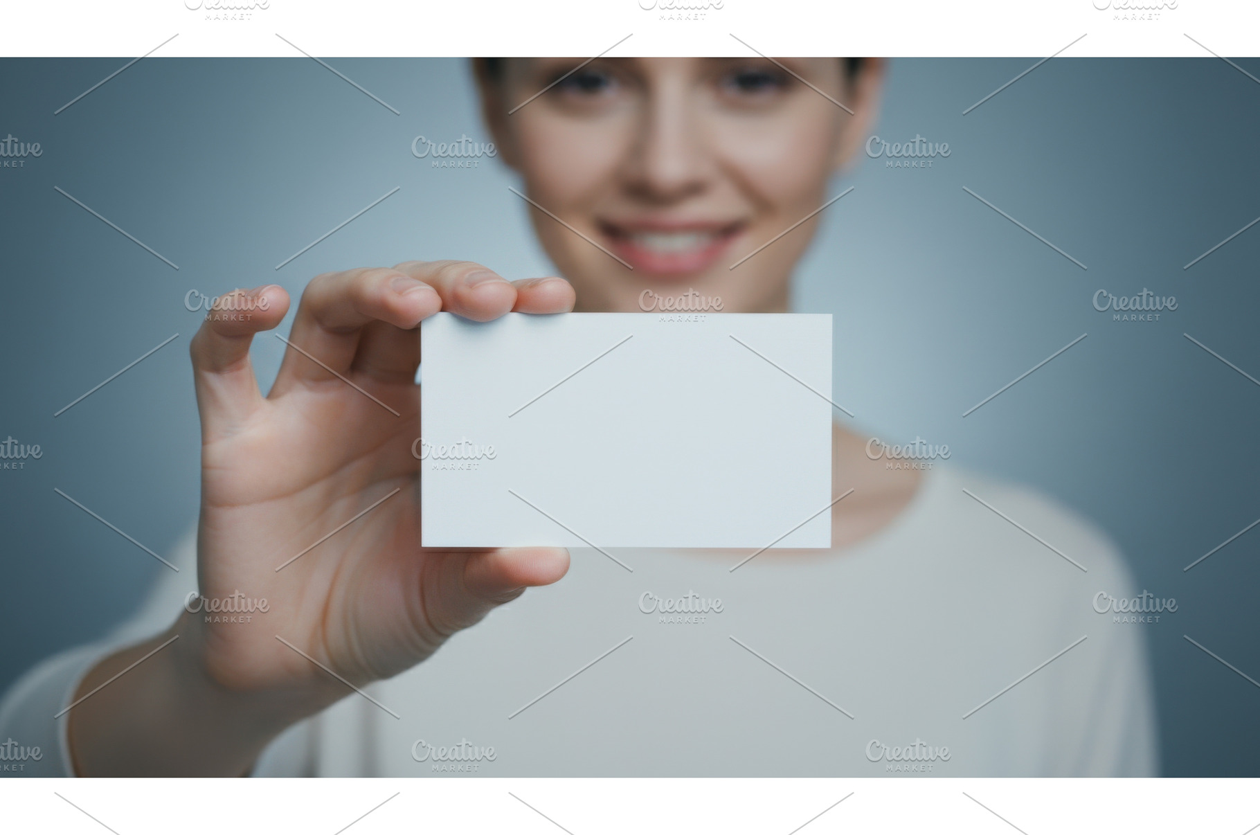 Smiling woman holding blank white, a Business Photo by Igor Tichonow