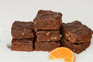 Stack of square baked slices of brownie chocolate cake with waln, a Food & Drink Photo by ndanko