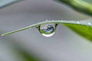 Earth Day concept with globe in Water droplet reflecting sky and, a Photo by Dvoevnore photos