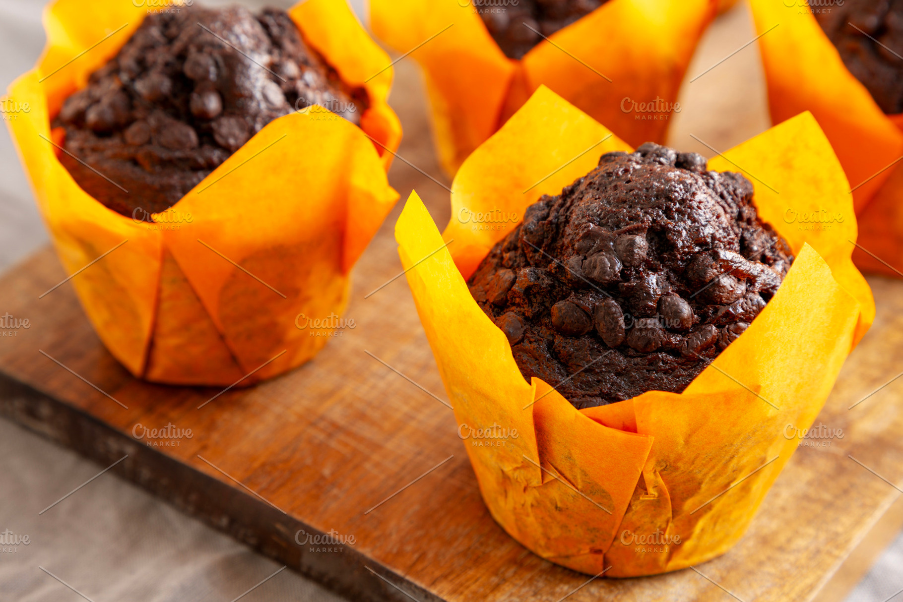 Homemade Chocolate Chip Muffins on a wooden board, side view. Cl, a Food & Drink Photo by LiudmylaChuhunova