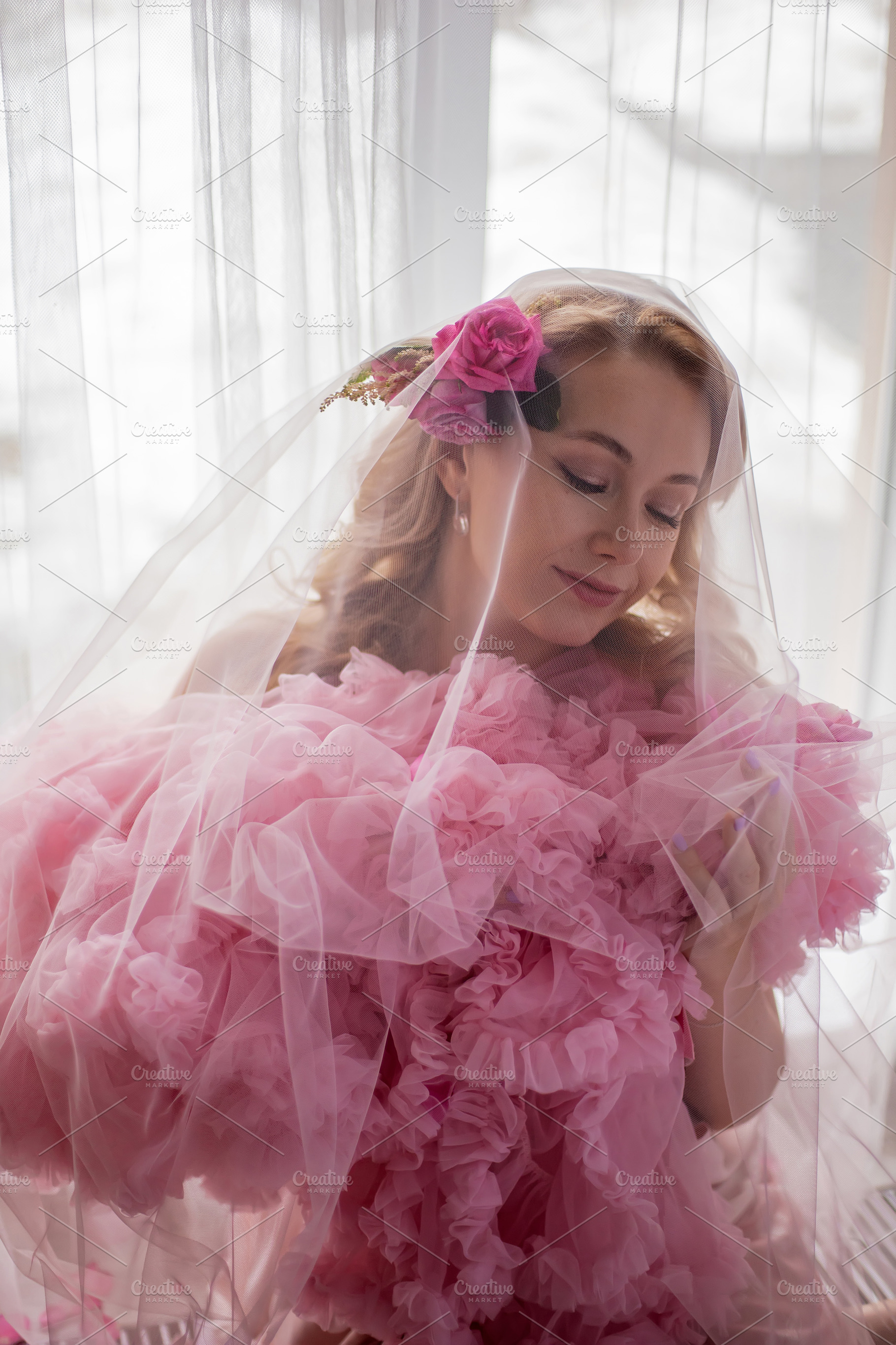 portrait of a fashionable blonde woman in a pink dress and rose flower in her h, a Person Photo by SaulichPhoto