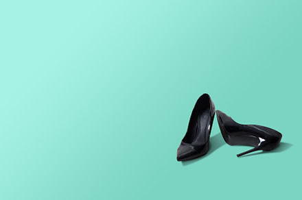 Black high heels isolated on a green