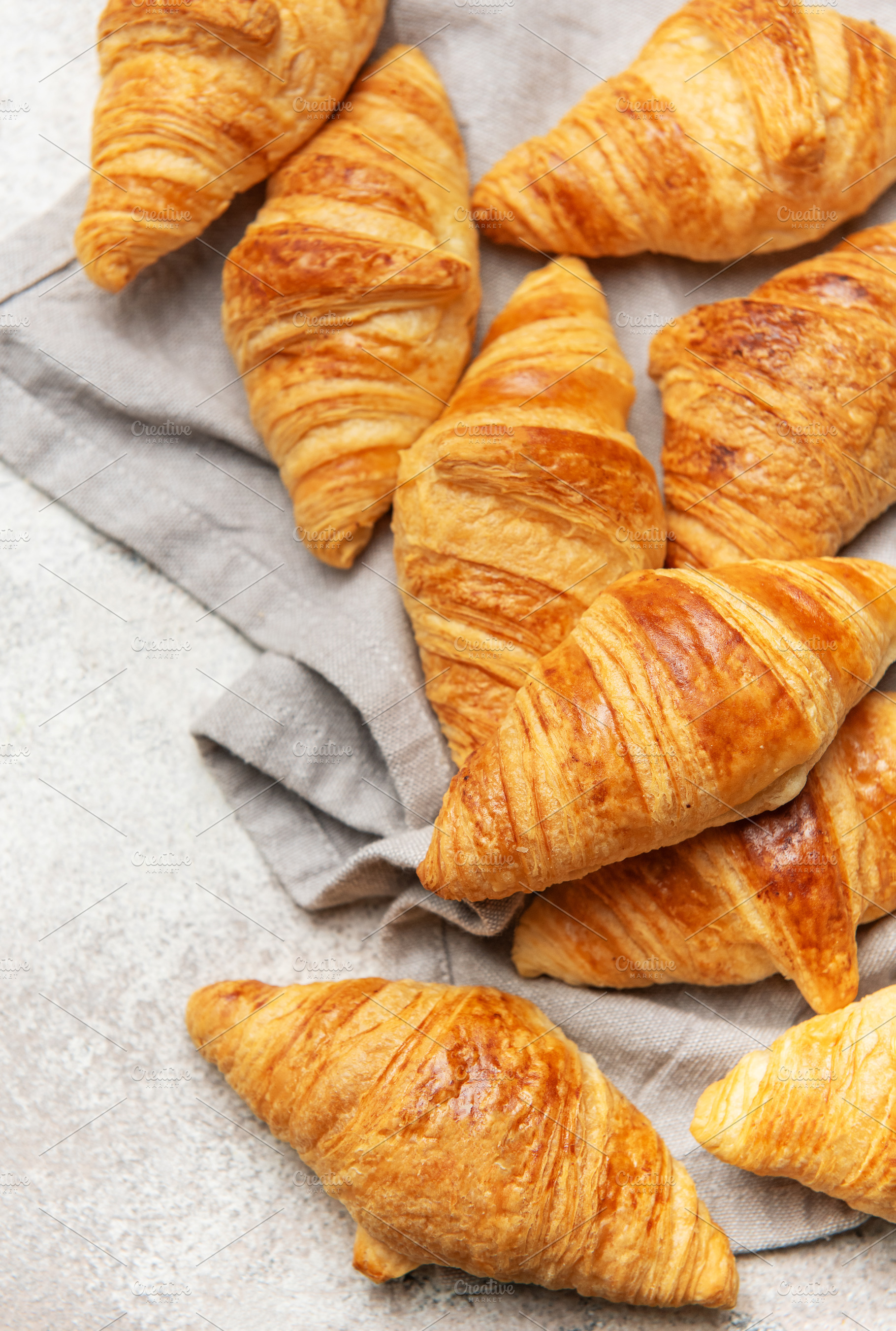 Freshly baked croissants resting on a gray cloth napkin, a Food & Drink Photo by Olena Rudo