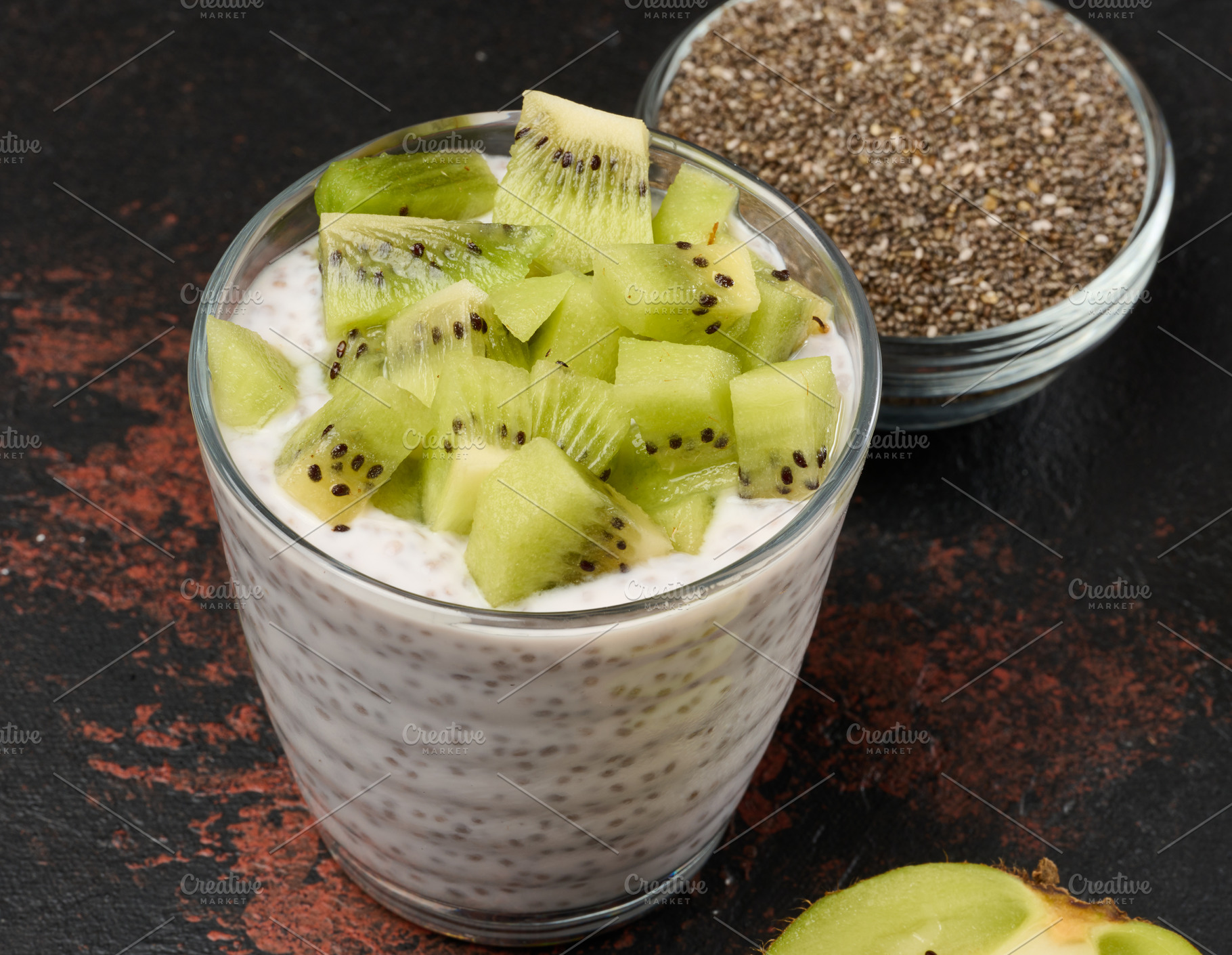 Glass of chia seed pudding mixed with diced kiwi is on a black s, a Food & Drink Photo by ndanko